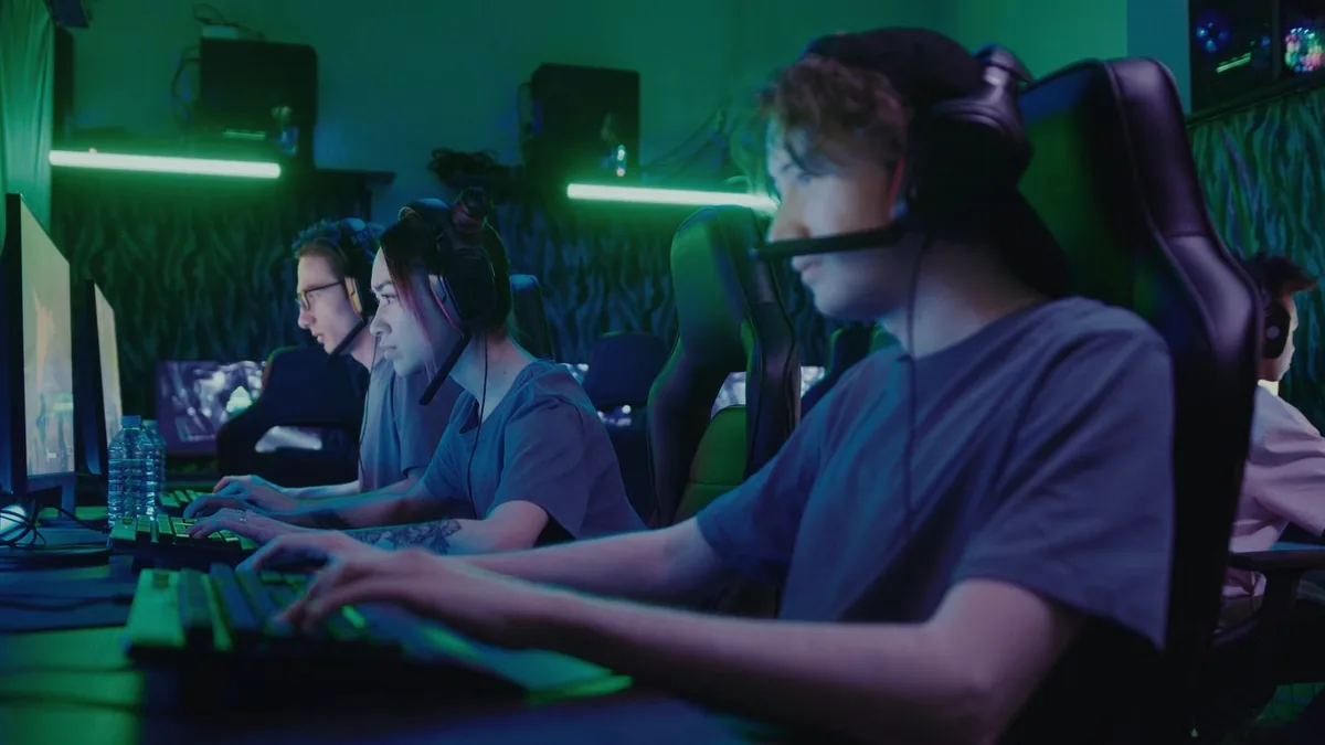 E-sportspelare vid datorer som illustrerar VPN för gaming, låg ping och säkrare spelanslutning
