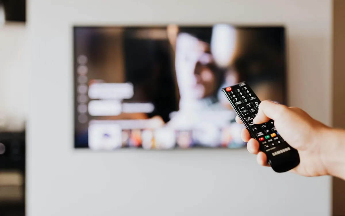 Fjärrkontroll framför tv som illustrerar VPN för Max och streaming utan tydlig tjänstelogotyp