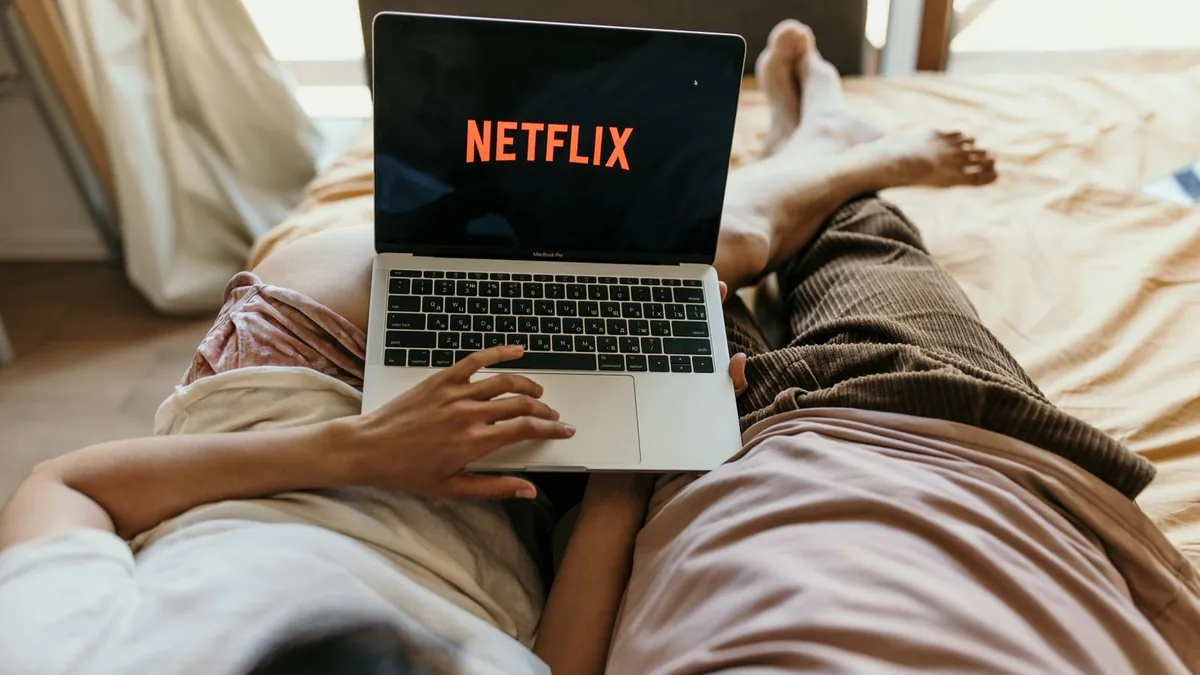 Par som tittar på Netflix på laptop, som illustrerar VPN för Netflix i Sverige